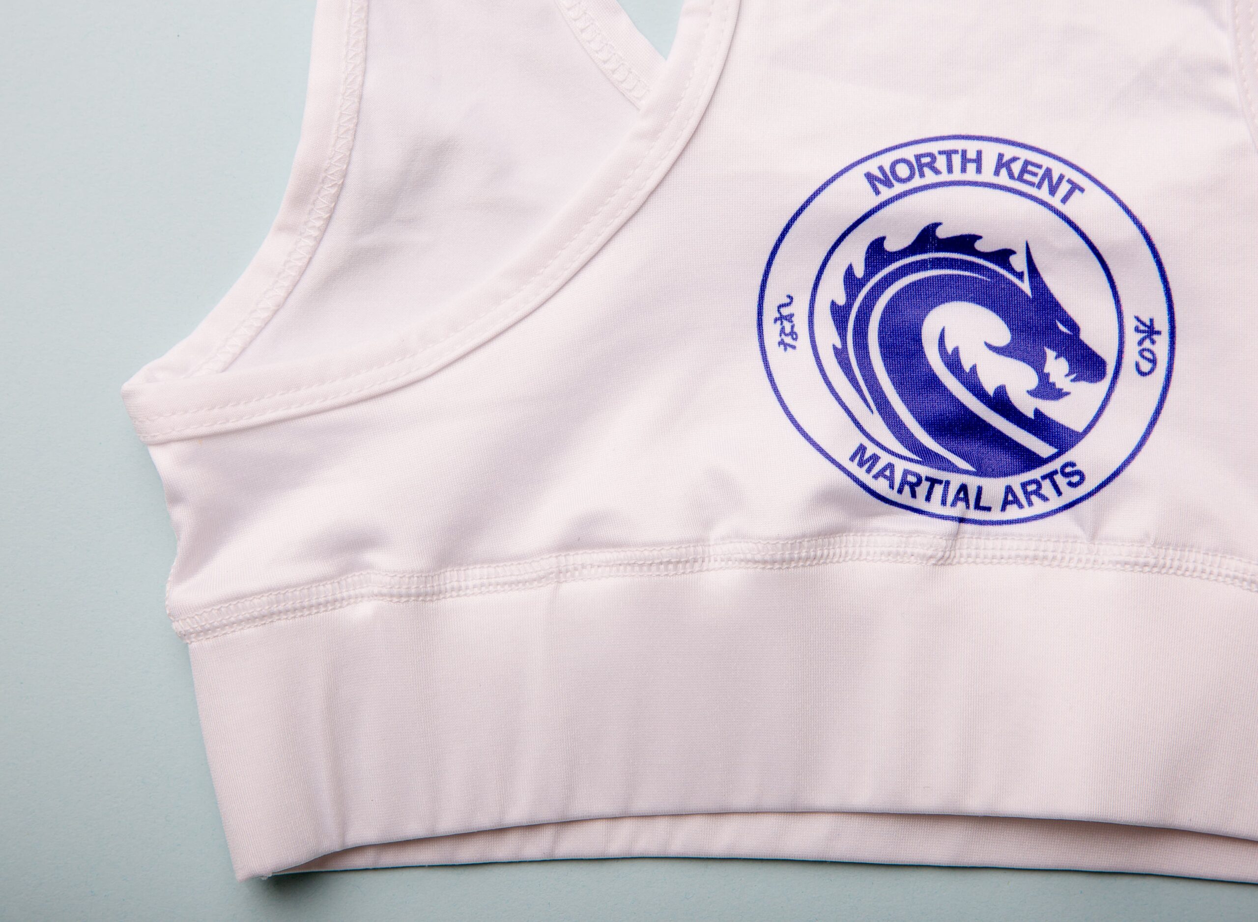 nkma white under gi crop top close up of rear design and logo