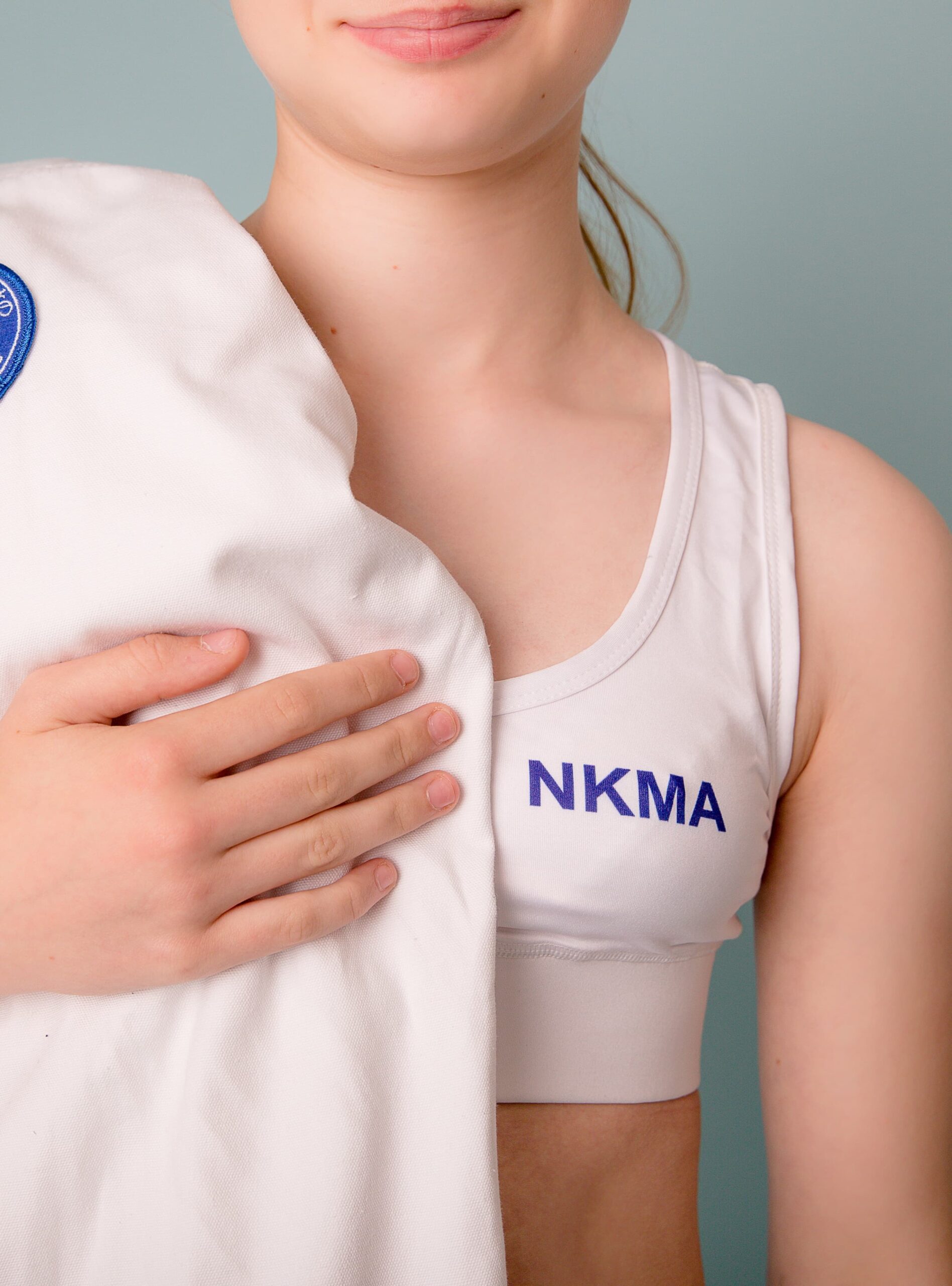 nkma white under gi crop top - close up on blonde model gi over shoulder